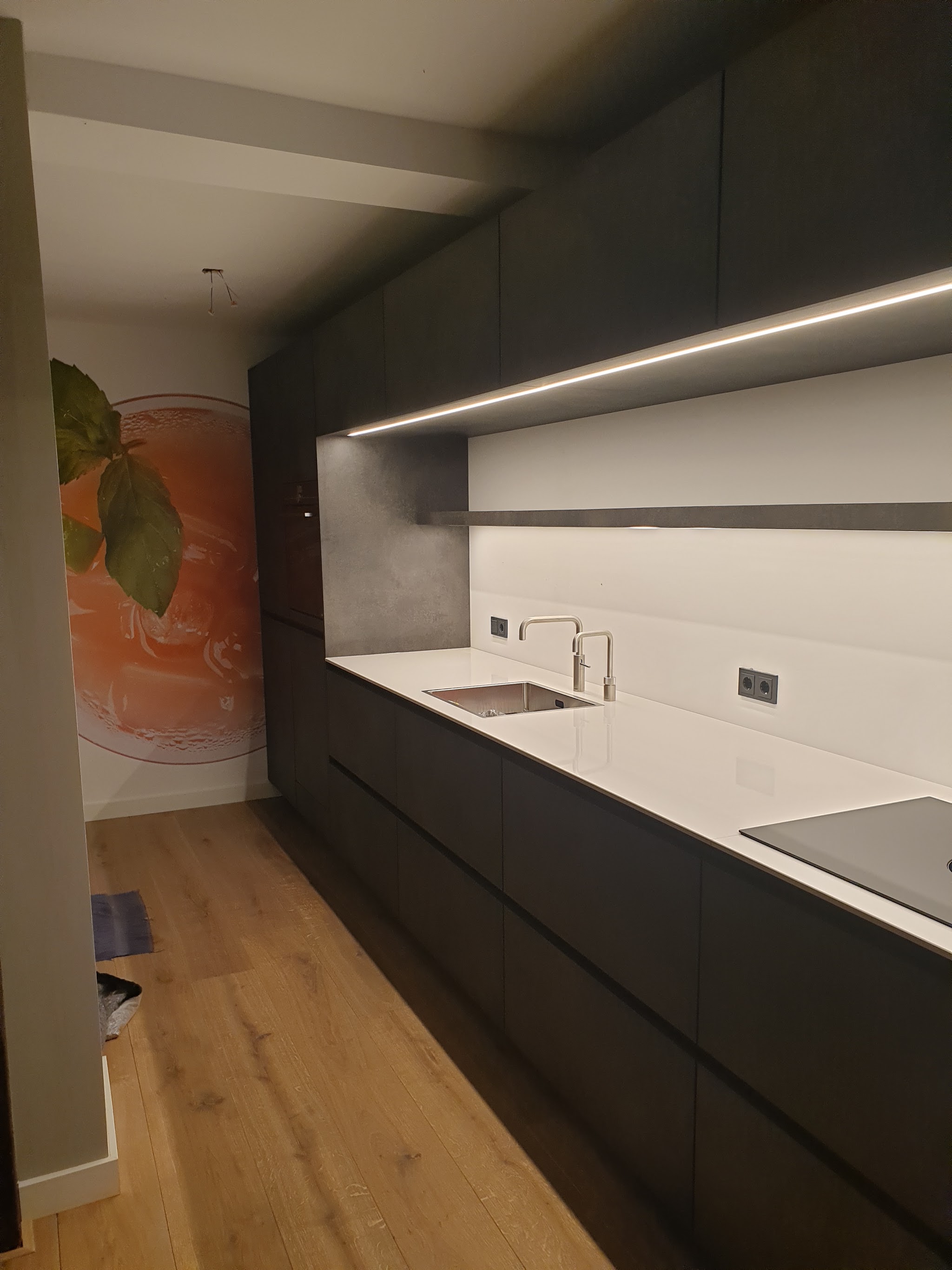Moderne donkere keuken met wit werkblad en eiken vloer